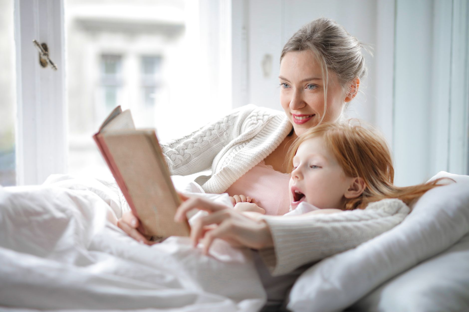 Mutter und Kind lesen gemeinsam und lachen